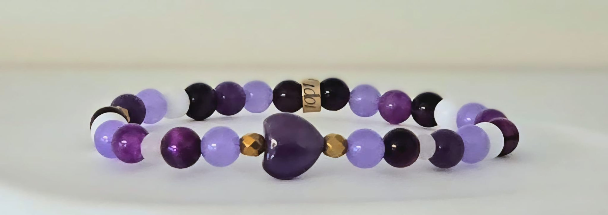 Bracelet Préma Quebec
Image principale : "Bracelet en pierres naturelles améthyste violette, œil de tigre, agate et jade"
Vue portée : "Bracelet multicolore en pierres naturelles porté au poignet"
Détail : "Perles de pierres naturelles améthyste, œil de tigre et jade sur bracelet élastique"