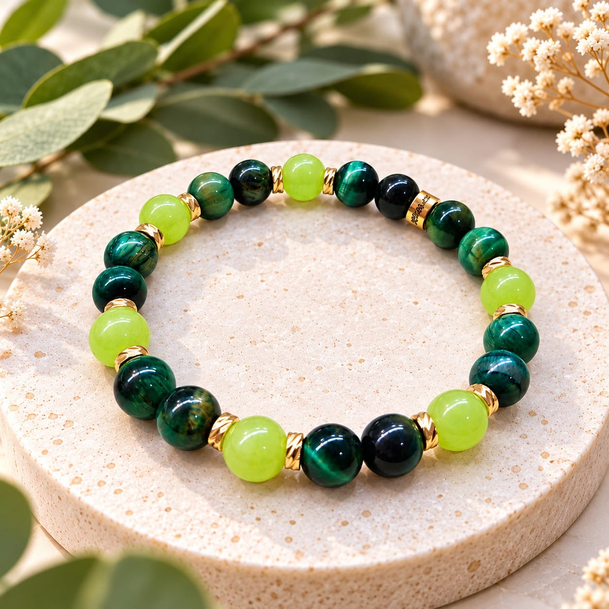 Bracelet Éclat de jade, jade vert et œil de tigre vert avec détails dorés sur un plateau décoratif