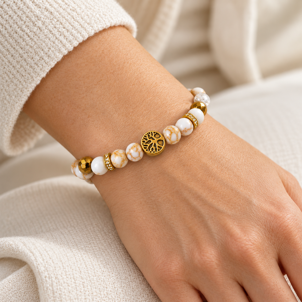 Bracelet Élégant blanc et doré avec arbre de vie porté au poignet d’une femme
