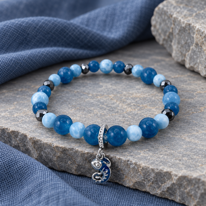 Bracelet caméléon, perles bleues et breloque argentée sur décor ardoise
