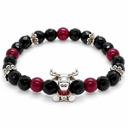 Bracelet Caribou, perles noires et bordeaux et breloque argentée sur fond blanc
